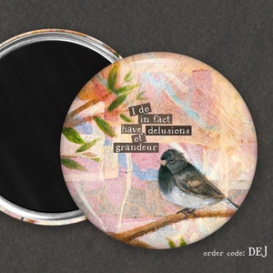 May include: A round magnet with a black background and a colorful image of a bird on a branch. The image has a quote that reads "I do in fact have delusions of grandeur".