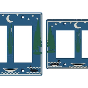 May include: Two blue light switch plates featuring a night scene with green pine trees, a white crescent moon, stars, and black geese swimming in water near a small boat. The plates have rectangular cutouts for switches.