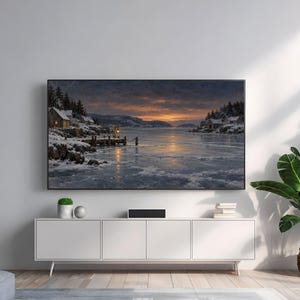 May include: A rectangular television screen displays a winter landscape painting featuring a snow-covered coastline, a wooden pier, and small cabins at twilight. The screen is mounted on a plain wall above a white four-door media console cabinet.