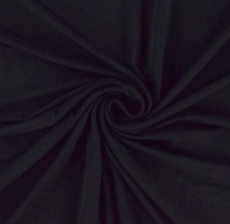 May include: A close-up of a dark blue fabric with a soft, smooth texture. The fabric is draped and folded, creating a swirling pattern.