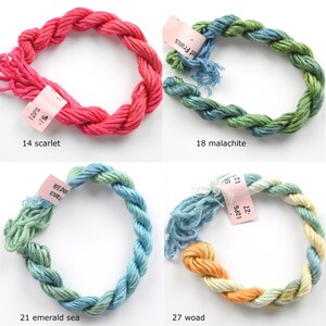 May include: Four skeins of embroidery floss in different colors: scarlet red, malachite green, emerald sea green, and woad yellow. Each skein is labeled with the color name and the number of skeins in the package.