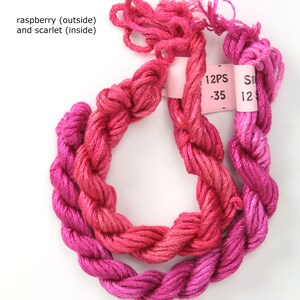 May include: Two skeins of embroidery floss, one raspberry pink and one scarlet red, with a pink label that reads "12PS -35".