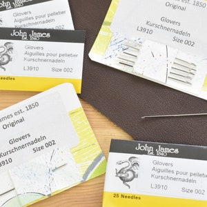 May include: Four packs of John James leather needles, size 002, with a yellow and white design. The packs are labelled "Glovers" and "Kurschnernadeln".