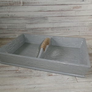 May include: A gray wooden tray with two divided sections and a jute rope handle. The tray has a distressed finish and is perfect for organizing small items.