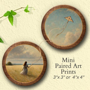 May include: Two mini framed art prints, one with a kite flying in a blue sky with clouds, and the other with a woman walking through a field of tall grass. The prints are 3 inches by 3 inches or 4 inches by 4 inches.