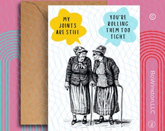 May include: Greeting card with a humorous illustration of two elderly women with walking sticks. One speech bubble says "MY JOINTS ARE STIFF" and the other says "YOU'RE ROLLING THEM TOO TIGHT". The card is paired with a brown envelope.