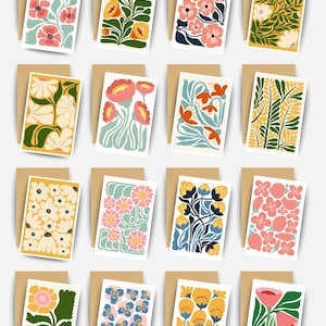 May include: A collection of sixteen floral art cards with matching brown envelopes. Each card features a unique, colorful floral design in shades of pink, yellow, blue, and green. The cards are rectangular and arranged in a grid, showcasing a variety of botanical illustrations.