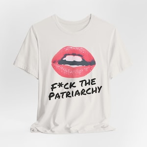 May include: White t-shirt with a red lips graphic and the text "F*CK THE PATRIARCHY" printed in black.