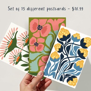 May include: Set of 15 different postcards featuring floral designs. The postcards feature a variety of colors and patterns, including pink, blue, yellow, and green.  Set of 15 different postcards - $18.99