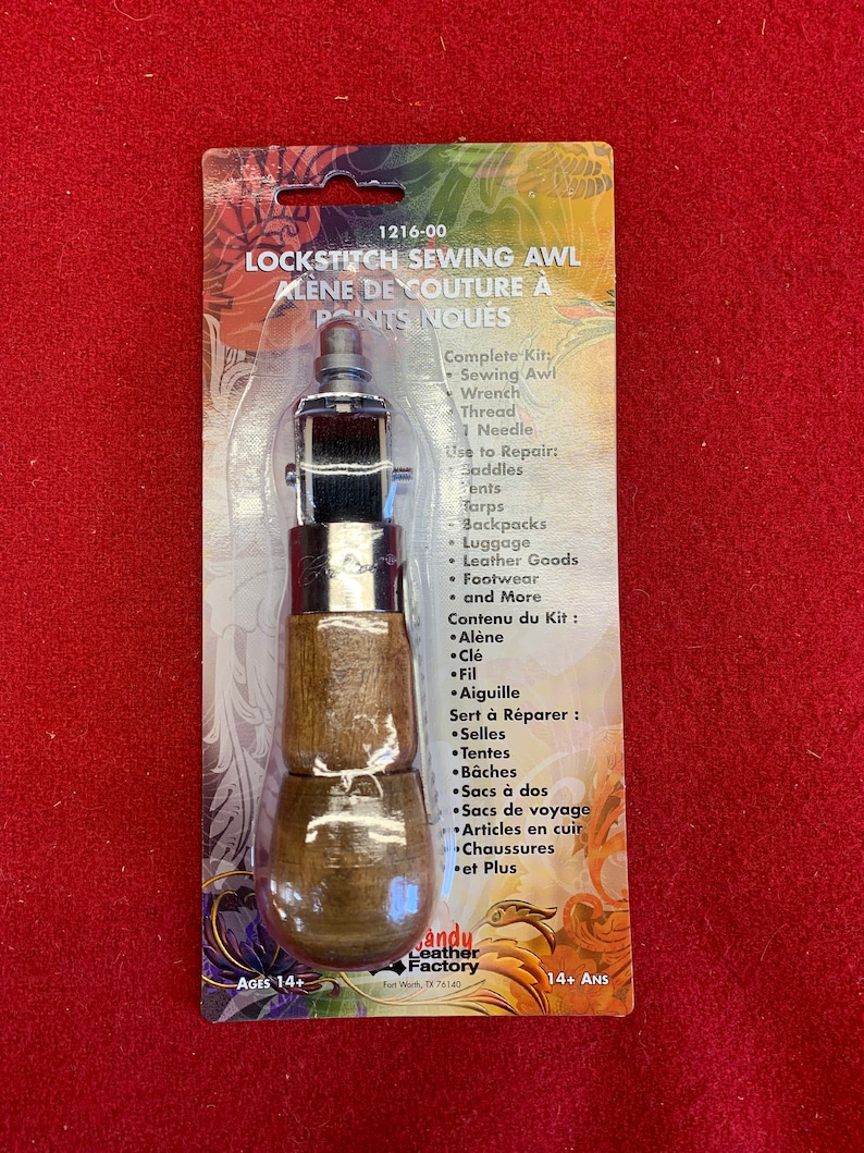 May include: A lock stitch sewing awl kit with a wooden handle and a metal awl. The kit includes a wrench, thread, and a needle. The packaging is labeled "1216-00 Lock Stitch Sewing Awl Alene de Couture a Points Noues" and "Andy Leather Factory".