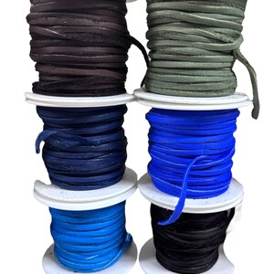 May include: Six spools of leather cord in various colors, including black, dark blue, light blue, green, and brown. The spools are stacked on top of each other.