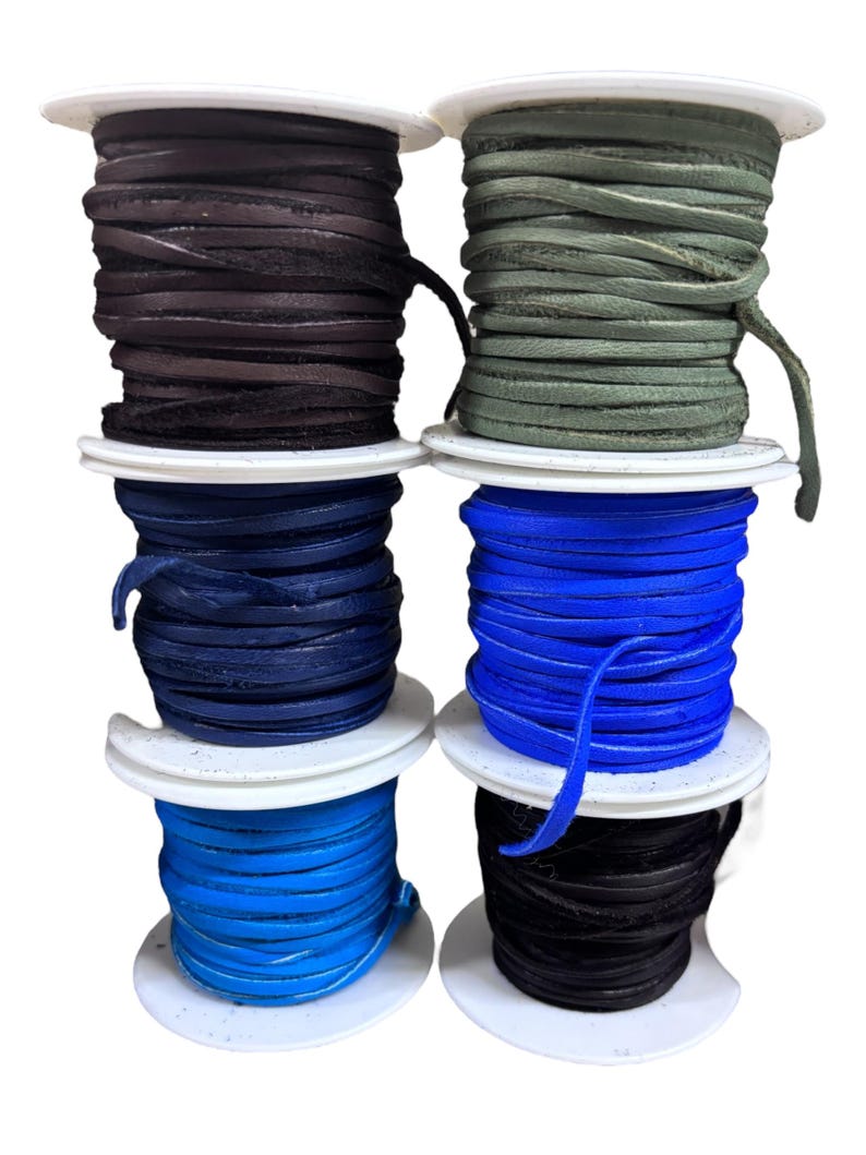 May include: Six spools of leather cord in various colors, including black, dark blue, light blue, green, and brown. The spools are stacked on top of each other.