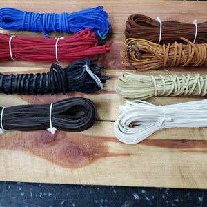 May include: Assortment of leather cord in various colors, including blue, red, black, brown, tan, green, and white. The cords are rolled up and tied with string.