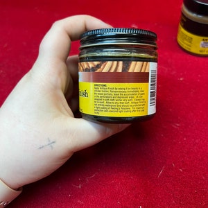 May include: A small glass jar of antique finish for leather. The jar is labeled with directions for use. The label reads: Apply Antique Finish by wiping it on heavily in a circular motion. Remove excess immediately, clear the raised portions, leave the accumulation of paste in the perforations and depressed areas. (A ruler wrapped in soft cloth works very well). Excess may be re-used. Allow to dry, then buff. Antique Finish is not entirely waterproof and should be protected with a light coating of Fiebing's Resolene. For maximum protection add a second light coating after first coat is dry.