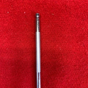 May include: A silver metal punch tool with a textured handle. The tool is about 6 inches long.