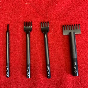 May include: Four black leather crafting tools with the word "Crafttool" engraved on each. The tools have different sized prongs for stitching leather.