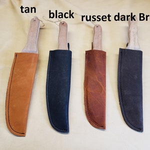May include: Four leather knife sheaths in tan, black, russet, and dark brown colors. The sheaths are hanging from a string.