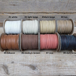 May include: Eight spools of leather cord in various colors, including white, beige, brown, tan, and rose. The spools are labeled with numbers 1 through 8 and color names.