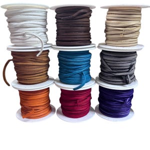 May include: Ten spools of leather cord in various colors, including white, brown, beige, tan, teal, gray, orange, red, and purple. The spools are arranged in three rows.