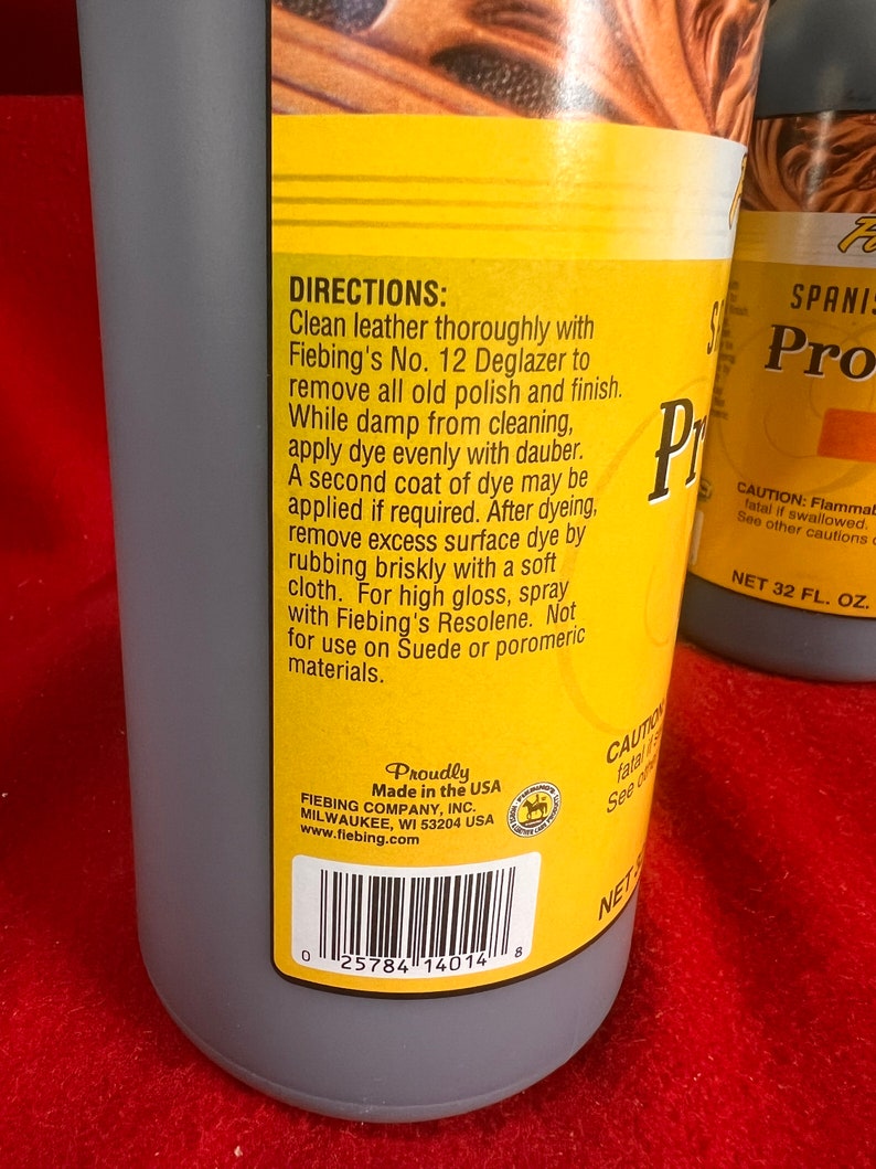 May include: A yellow and black bottle of Fiebing's No. 12 Deglazer leather cleaner. The bottle is labeled with directions for use and a warning about flammability. The bottle is made in the USA and has a barcode.