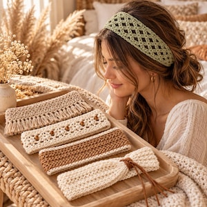 May include: A collection of four crochet headbands arranged on a wooden tray. The set includes a beige headband with fringe, a cream headband with wooden beads, a brown and cream striped headband, and a cream headband with a leather cord tie.