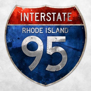 May include: A vintage-style Interstate 95 road sign. The sign is shield-shaped with a red top section and a blue lower section. The words "INTERSTATE" and "RHODE ISLAND" are displayed, along with the number "95" in a silver font.