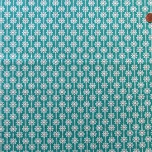 Könnte beinhalten: Tealfarbener Stoff mit einem weißen, sich wiederholenden Muster aus kleinen, stilisierten Blumen. Das Muster ist in vertikalen Reihen angeordnet.