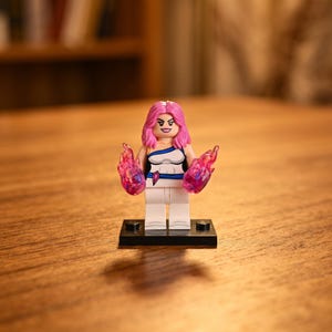 May include: A plastic minifigure with bright pink hair and a determined facial expression. The figure wears a white and blue outfit with a small purple gem detail and holds translucent pink flame-like accessories in each hand.
