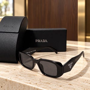 PRADA Svarta rektangulära solglasögon med grå linser och breda logotypskalmar, vinklade bågar med fodral, ask och rengöringsduk