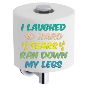 May include: White toilet paper roll with a blue, green, yellow, and pink embroidered design that says "I laughed so hard tears ran down my legs".