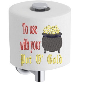 May include: White toilet paper roll with a gold pot of gold and the text "To use with your Pot O' Gold" in red and gold embroidery.