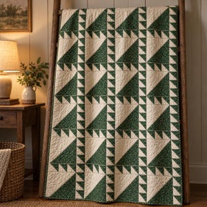 May include: A rectangular quilt featuring a repeating geometric pattern of dark green triangles with a subtle white floral print, alternating with solid cream-colored triangles. The fabric has a visible quilted texture throughout the entire surface.