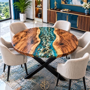 May include: A round dining table featuring a natural wood slab top with a central river-like inlay of blue resin and smooth river stones, supported by a black metal X-shaped base, accompanied by four beige upholstered chairs.