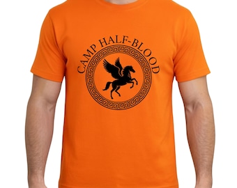 May include: A bright orange short-sleeved t-shirt featuring a black graphic print on the chest. The design includes a circular Greek key border surrounding a silhouette of a winged horse, with the text CAMP HALF-BLOOD arched above.