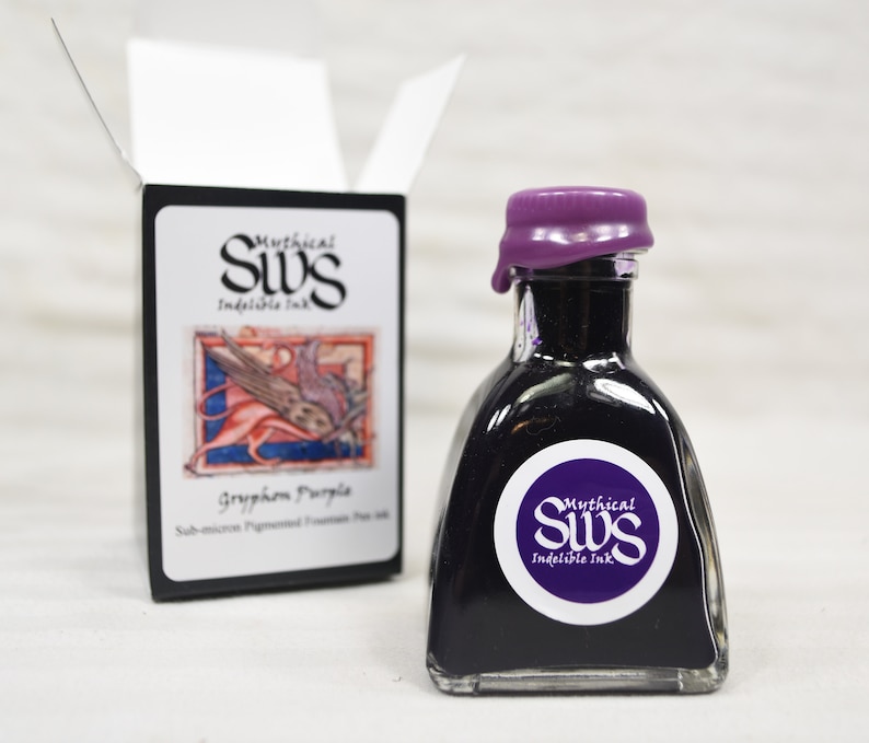 K&ouml;nnte beinhalten: Eine kleine, klare Glasflasche gef&uuml;llt mit tiefvioletter Tinte, verschlossen mit einem violetten Wachsverschluss. Die Flasche hat ein wei&szlig;es Etikett mit dem Text "Mythical SWS Indelible Ink" und einem lila Kreislogo. Eine schwarze Schachtel mit dem gleichen Logo und Text daneben.