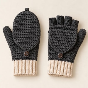 May include: A pair of dark charcoal gray crochet convertible mittens with a ribbed beige cuff. The mittens feature a fold-over flap secured by a small brown button, allowing them to function as both fingerless gloves and full mittens.
