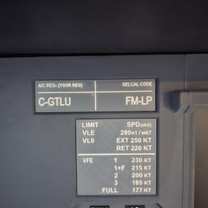 May include: A dark gray aircraft cockpit panel featuring white printed text. The top section displays A/C REG: C-GTLU and SELCAL CODE: FM-LP. Below, a speed limit table lists VLE 280KT/M67, VLO EXT 250KT, RET 220KT, and VFE settings from 1 to FULL.