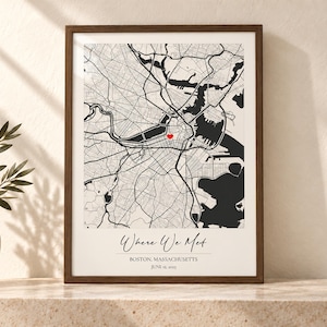 May include: A framed map print of Boston, Massachusetts, featuring black street lines on a white background with a small red heart icon. The text reads Where We Met, BOSTON, MASSACHUSETTS, and JUNE 22, 2023, in a dark brown wooden frame.