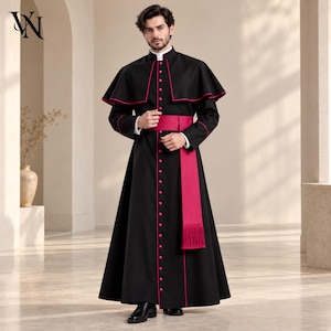 May include: A black cassock featuring a high collar, long sleeves, and a row of buttons down the front. The garment includes a shoulder cape and a wide, vibrant magenta sash with fringe detailing at the end, accented by magenta piping.