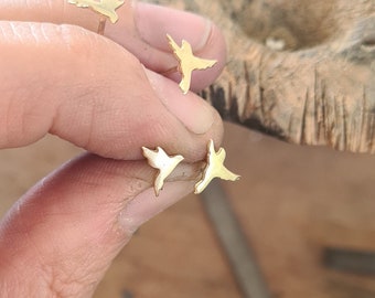 May include: Three gold bird-shaped stud earrings. The earrings are small and delicate, and they are perfect for adding a touch of whimsy to any outfit.