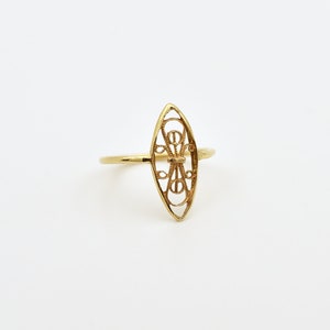 Puede incluir: Un anillo de filigrana dorada con un dise&ntilde;o en forma de diamante. El anillo es delicado e intrincado.