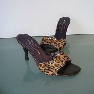 Puede incluir: Una taza de cer&aacute;mica blanca con un asa negra y el texto "But First, Coffee" en negro, con una fuente de estilo manuscrito. La taza est&aacute; sobre una superficie blanca.