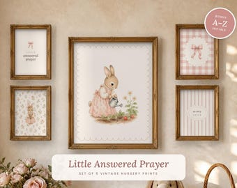 May include: A set of five framed wall art prints featuring a central illustration of a rabbit in a pink dress watering flowers, surrounded by four smaller prints with floral patterns, stripes, a pink bow, and the text Little Answered Prayer.