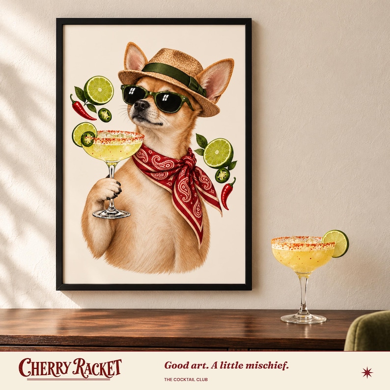 Op de afbeelding: Een ingelijste kunstdruk van een beige chihuahua met een strooien hoed, zwarte zonnebril en een rode paisley bandana. De hond houdt een margaritaglas vast, omringd door zwevende limoenschijfjes, jalape&ntilde;o's en rode chilipepers.