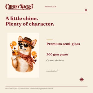 May include: A print featuring a dog wearing a brown fedora, sunglasses, and a red paisley bandana, holding a cocktail with orange slices and cherries. Text reads Cherry Racket, The Cocktail Club, A little shine. Plenty of character. Premium semi-gloss 200 gsm paper.