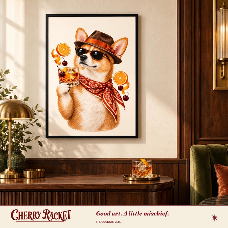 May include: A framed wall art print featuring a Corgi dog wearing a brown fedora, black sunglasses, and a red paisley bandana. The dog holds a glass of amber liquid with ice, surrounded by floating orange slices and cherries.
