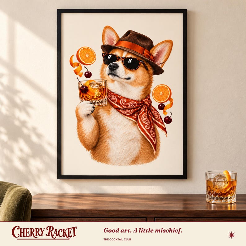 May include: A framed wall art print featuring a tan and white Corgi wearing a brown fedora, black sunglasses, and a red paisley bandana. The dog holds a glass of amber liquid with a cherry and orange slice, surrounded by floating orange slices and cherries.