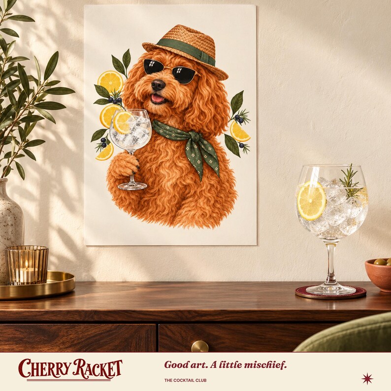 May include: A wall art print featuring a fluffy ginger dog wearing a straw fedora, dark sunglasses, and a green patterned neckerchief. The dog holds a glass of gin and tonic garnished with a lemon slice, surrounded by lemon and juniper illustrations.