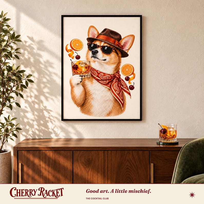 May include: A framed wall art print featuring a tan and white Corgi wearing a brown fedora, black sunglasses, and a red paisley bandana. The dog holds a glass of amber liquid with orange slices and cherries floating around it.
