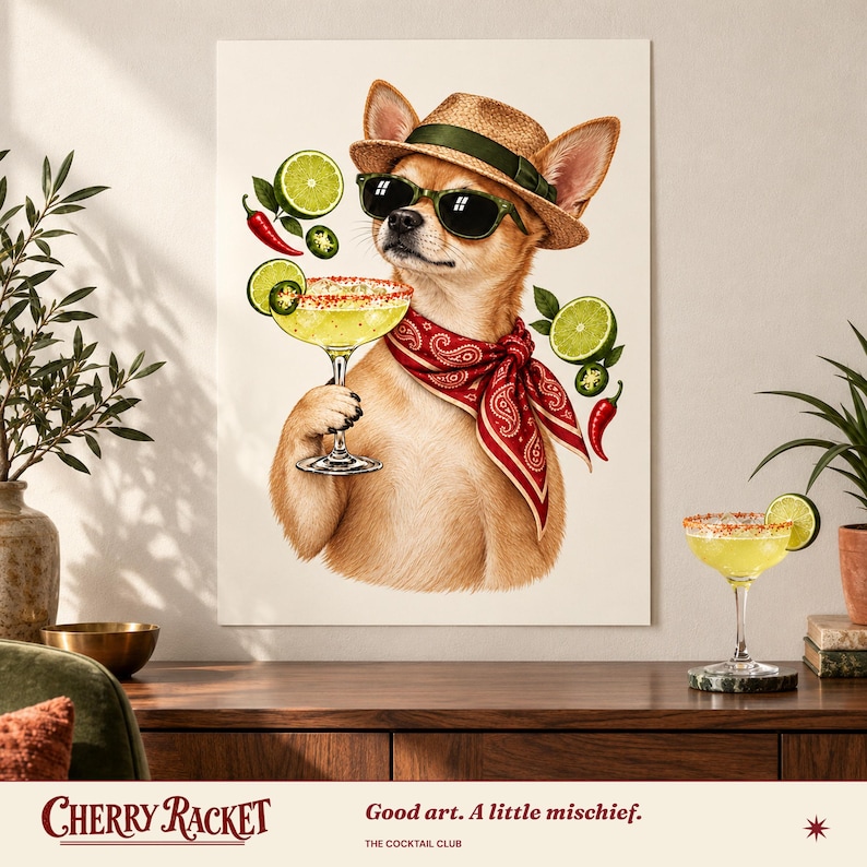 Op de afbeelding: Een wandkunstprint met een beige chihuahua die een strooien hoed, een zwarte zonnebril en een rode paisley bandana draagt. De hond houdt een margaritaglas met een zoutrand vast, omringd door zwevende limoenschijfjes en rode chilipepers.